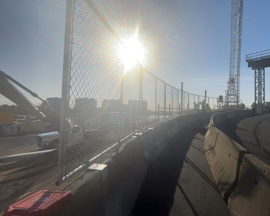 barrier fence system being installed near bridge