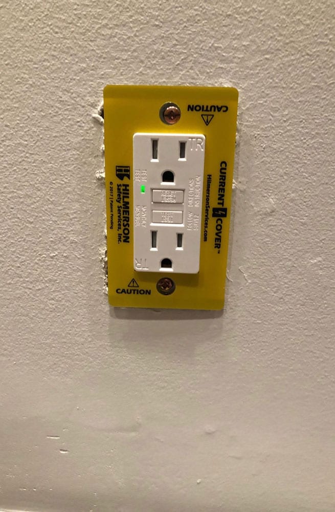 Safety outlet cover around a wall outlet OSHA compliant