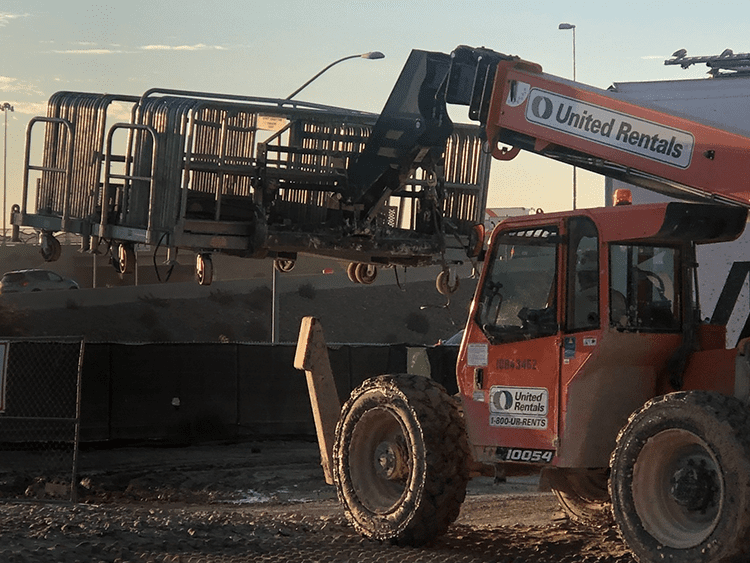 Galvanized safety rail being moved by forklift