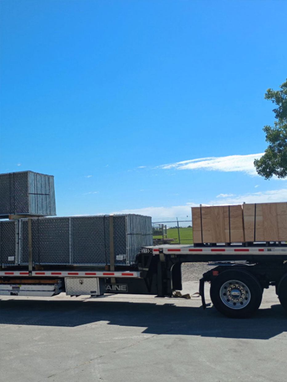 Flatbed trailer transporting multiple large crates and secured containers