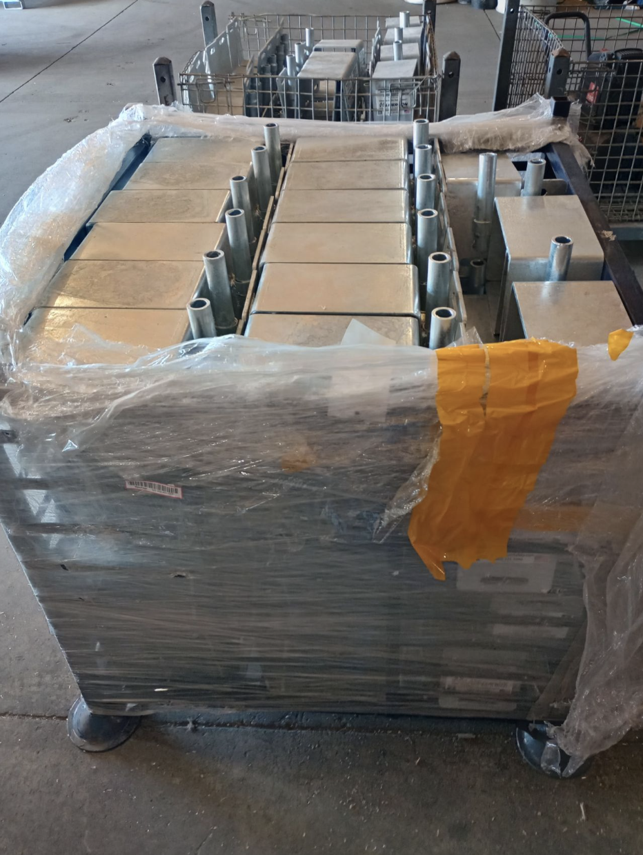 Large rectangular metal components stacked on a wrapped pallet